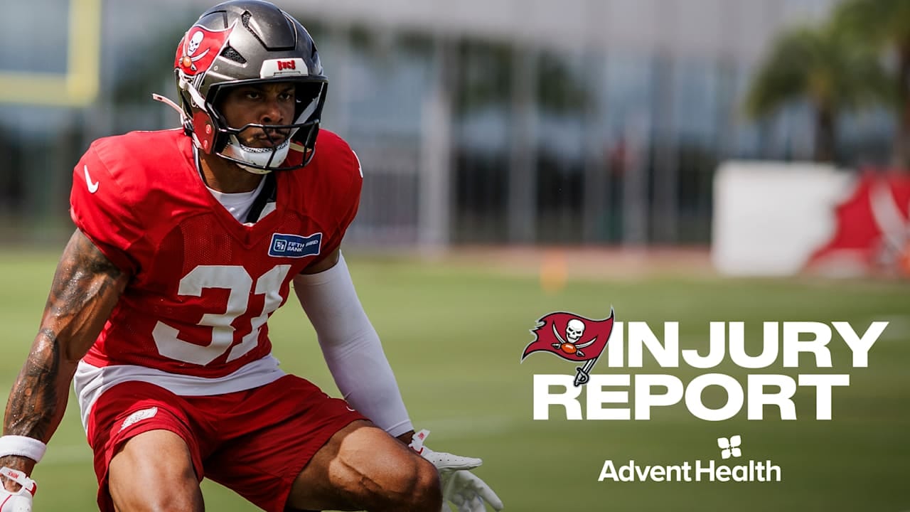 Un jugador de los Buccaneers con el número 31 y casco plateado se agacha en la práctica, junto al texto "Injury Report".