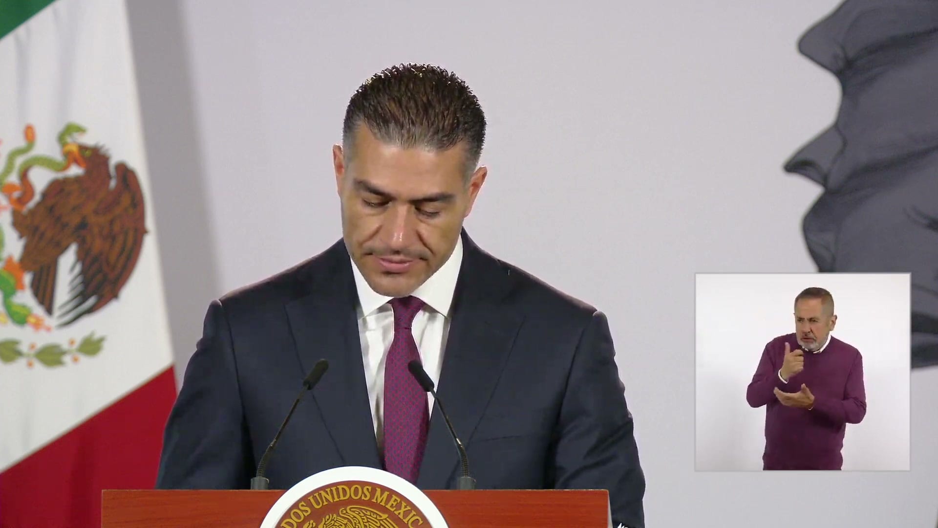 El secretario Omar García Harfuch, con la vista baja, de pie tras el podio de la conferencia matutina.