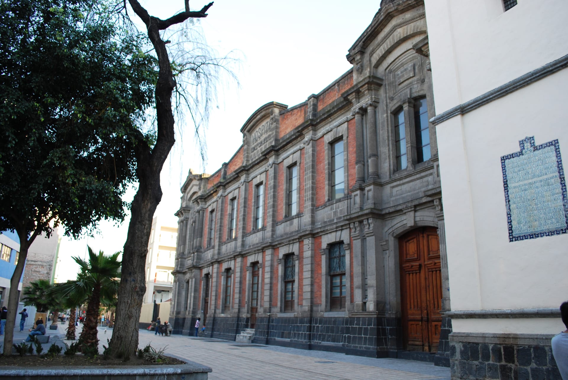 Fachada de ladrillo rojo y piedra gris de un antiguo edificio de hospital en el centro de la Ciudad de México.