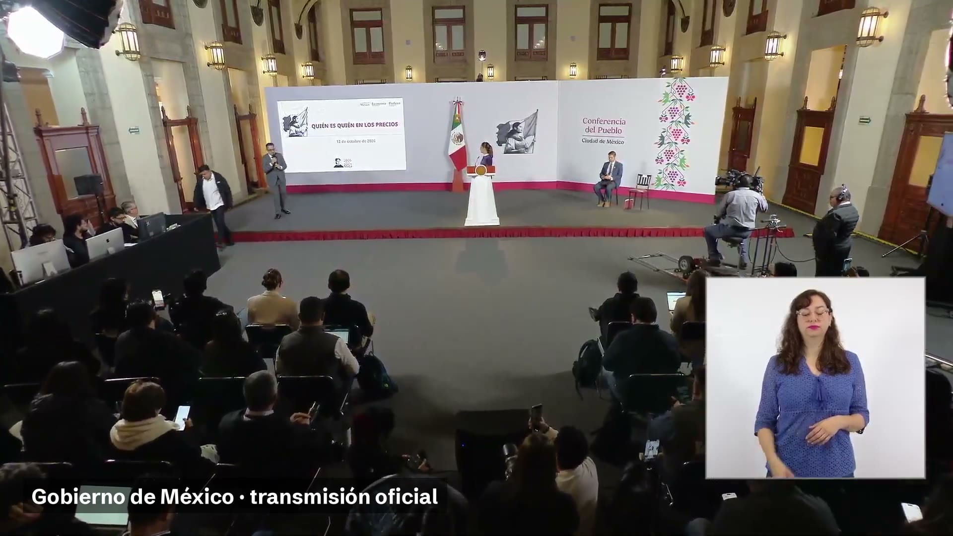 Salón de la conferencia matutina con la presidenta en el podio y una pantalla que dice Quién es quién en los precios.