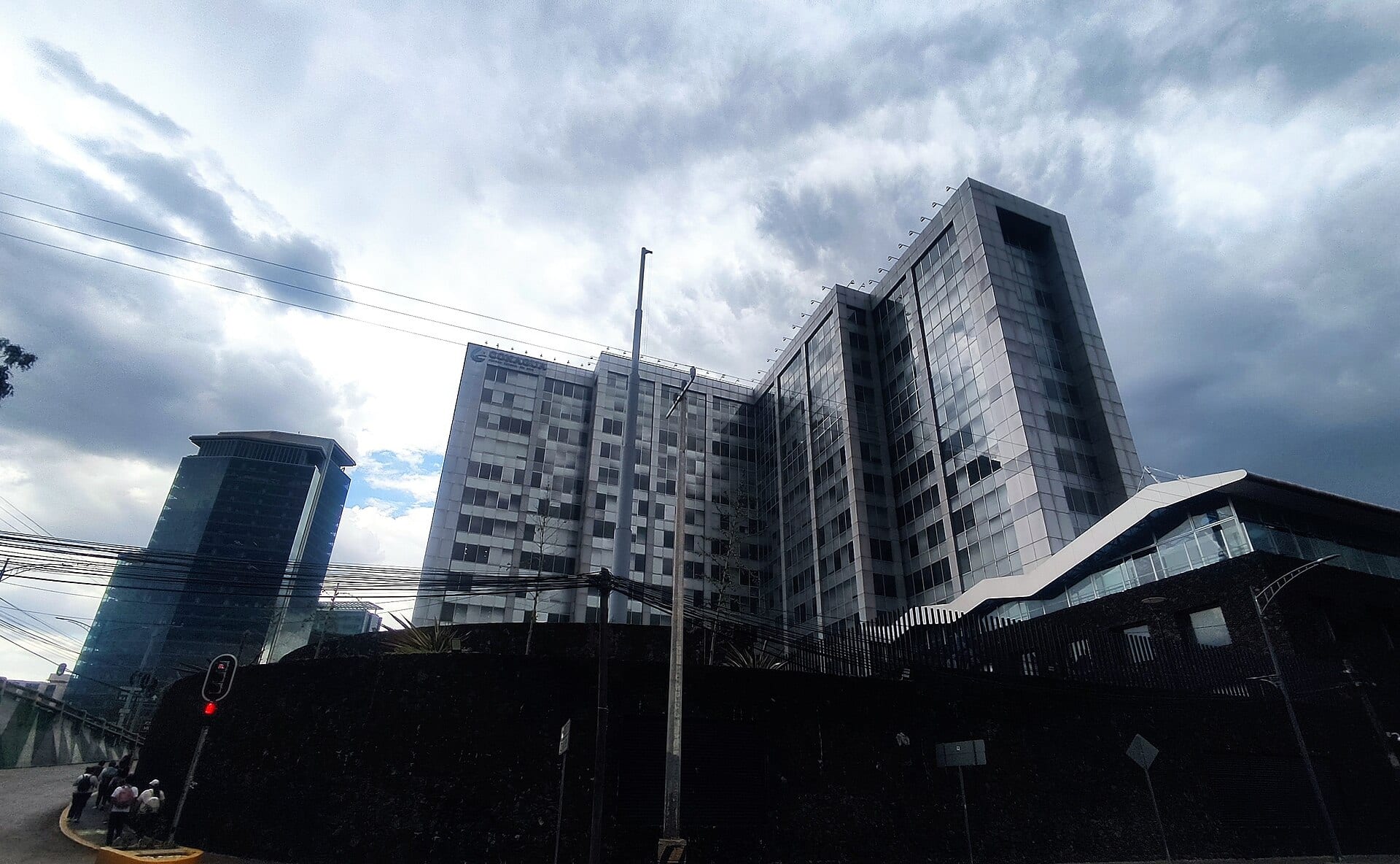 Edificio de oficinas de varios pisos con fachada de vidrio y el logotipo de la Comisión Nacional del Agua en la parte alta, bajo un cielo nublado.
