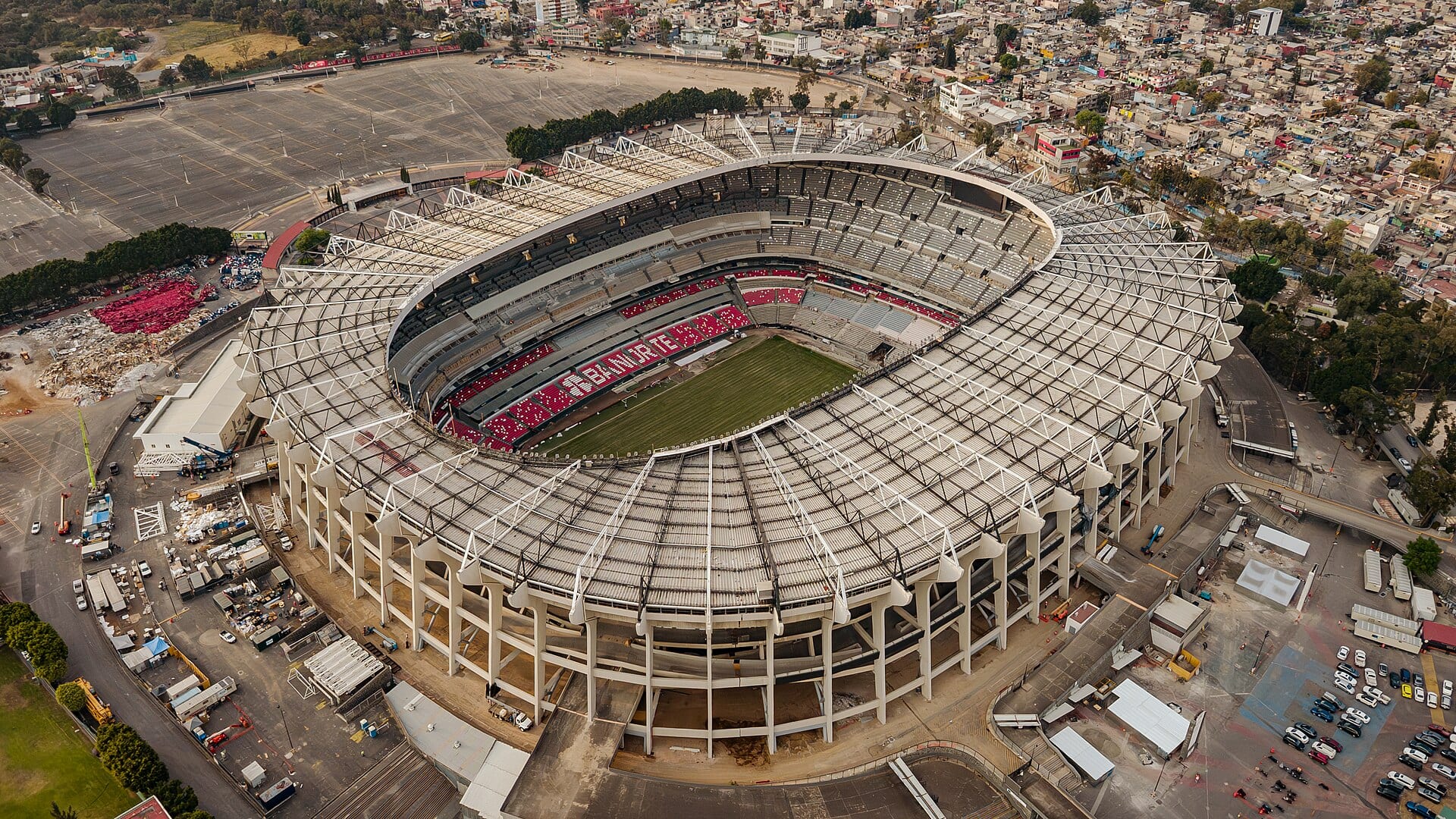 Vista aérea del Estadio Banorte, de forma circular, con su explanada y estacionamientos alrededor.