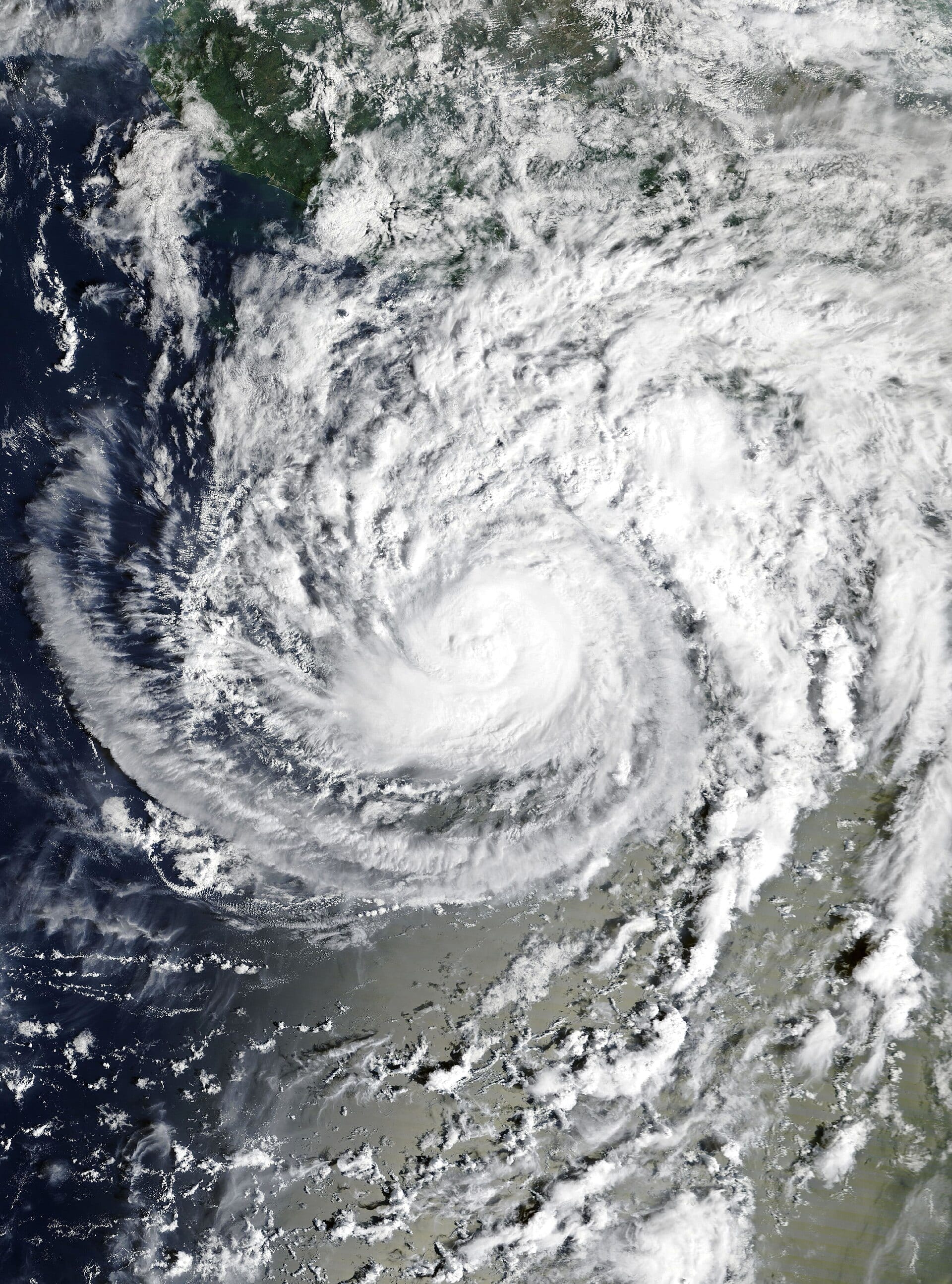 Satellite view of Trudy, a spiral of white clouds with a central eye over the ocean, with Mexico's Pacific coast at the upper left.