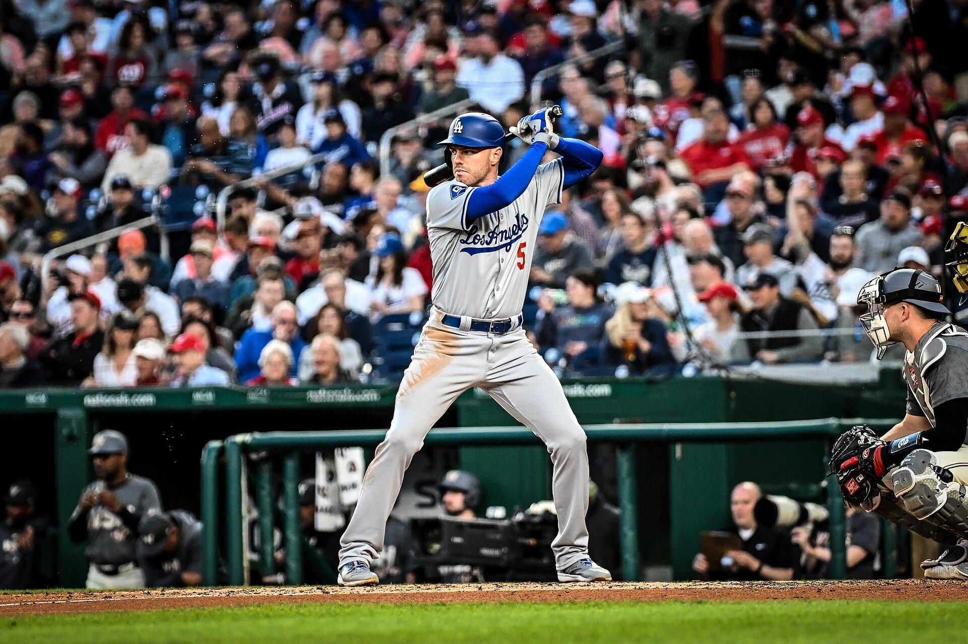 Freddie Freeman, con uniforme gris de los Dodgers, espera el lanzamiento en posición de bateo mientras el receptor se agacha detrás de él.