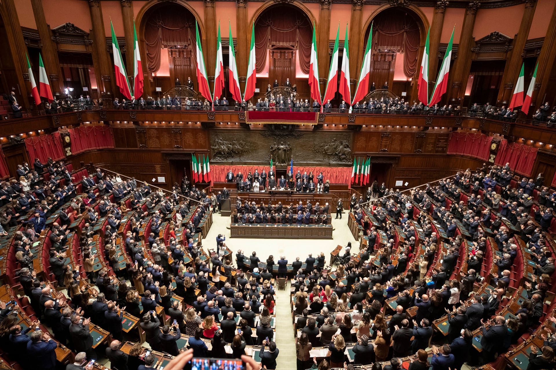 View of the Chamber of Deputies hall in Montecitorio Palace, with rows of seats in a semicircle and the presidency desk at the front.