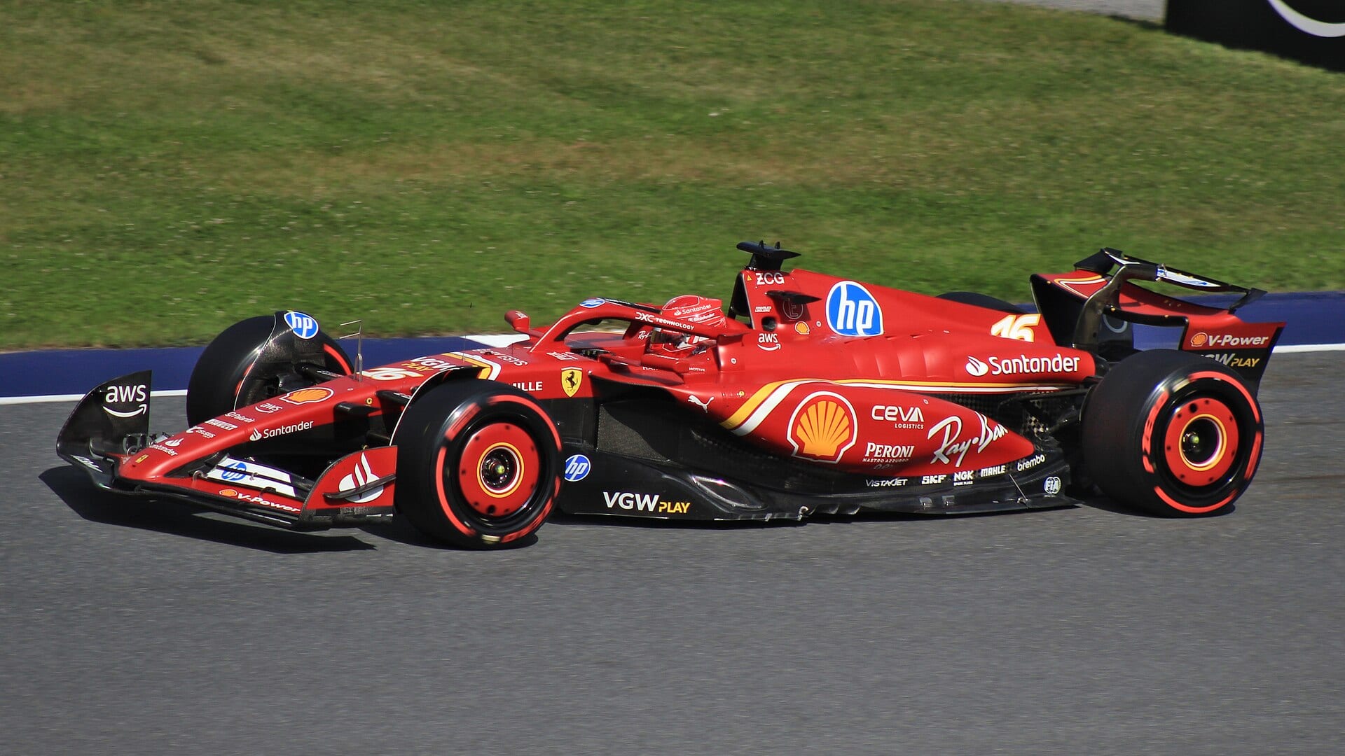 El Ferrari número 16 de Charles Leclerc rueda por la pista con neumáticos blandos de aro rojo, visto de lado.