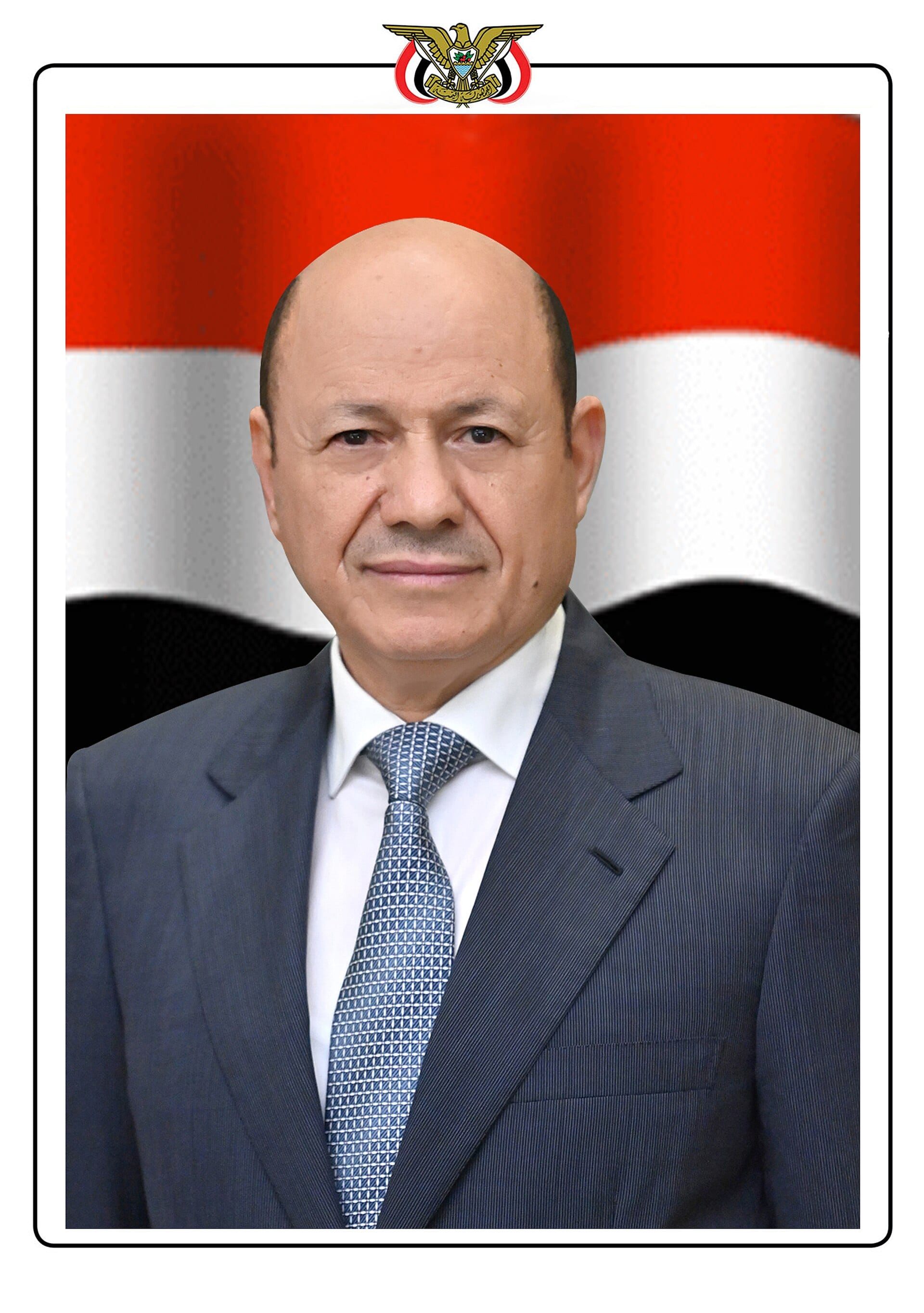 Official portrait of Rashad al-Alimi, a bald man in a gray suit and blue tie, in front of the Yemeni flag with the eagle emblem at the top.