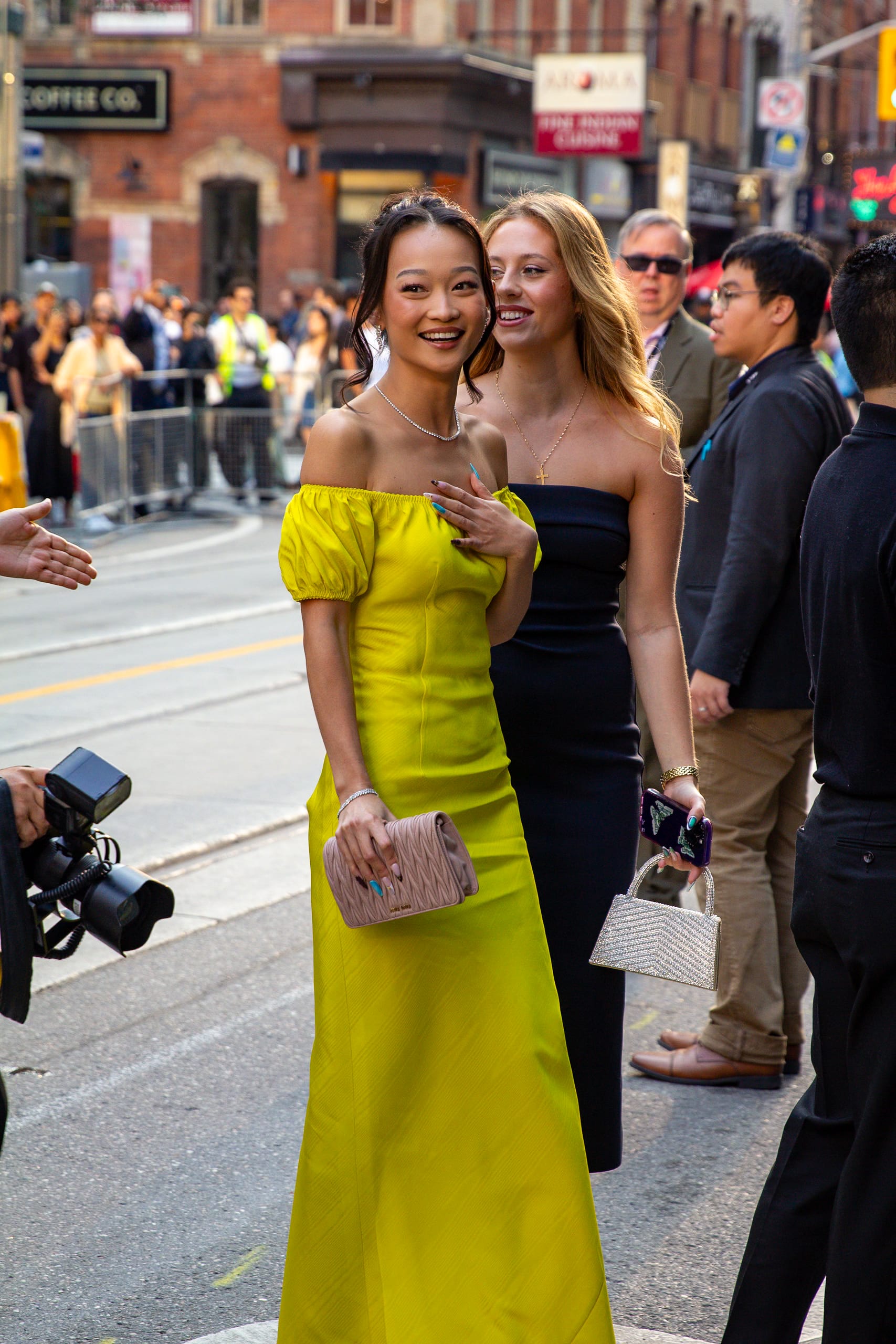 La actriz Callina Liang, de vestido amarillo, sonríe a la cámara en una calle de Toronto durante el festival de cine de 2024.