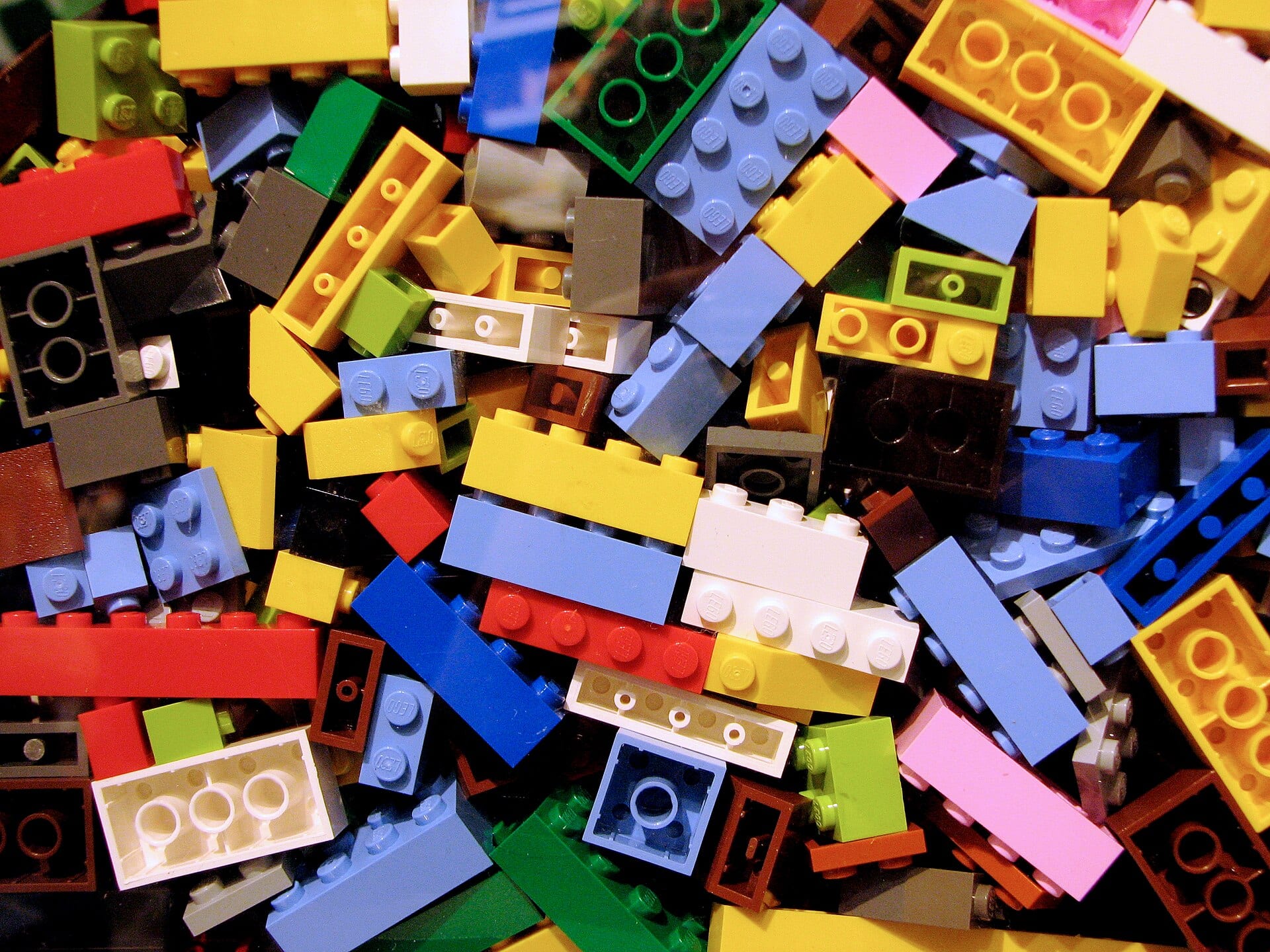 Un montón de piezas de plástico de construcción de distintos colores y formas, apiladas de cerca.