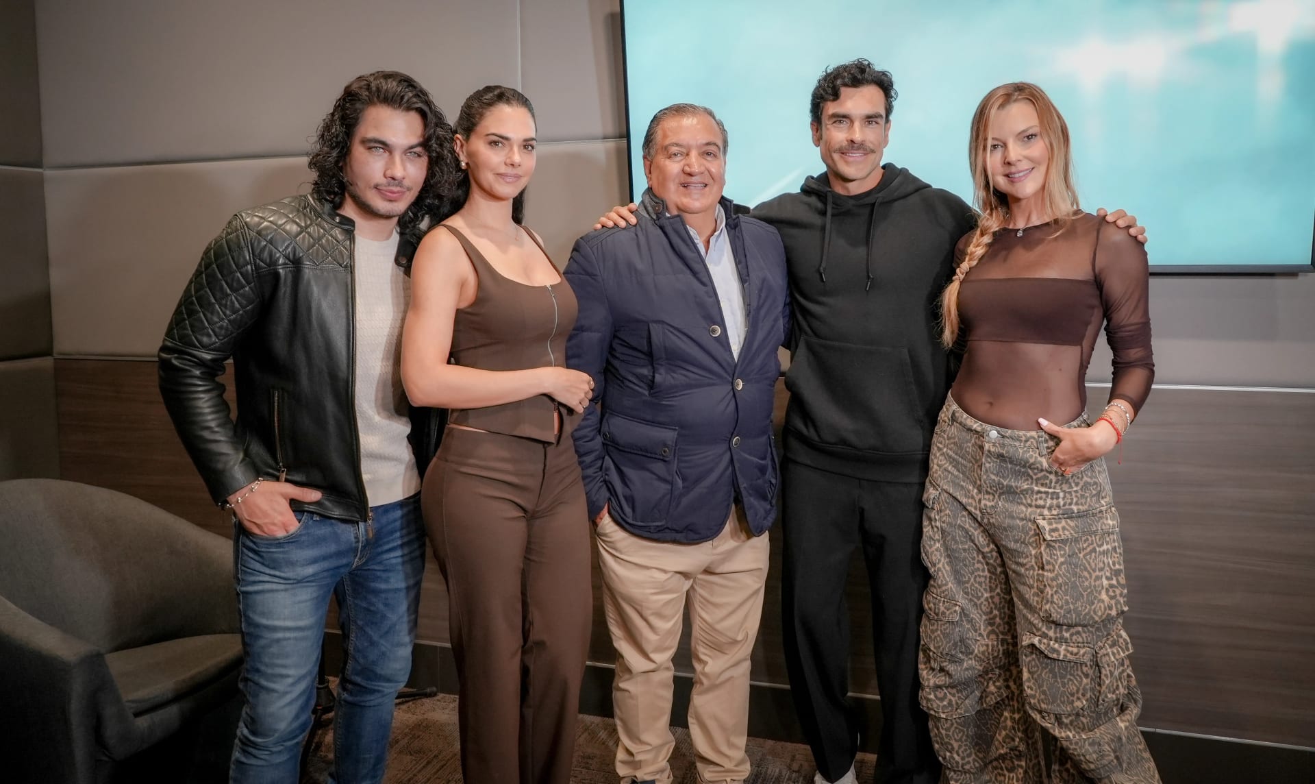 Cinco personas posan juntas frente a una pantalla en un estudio, durante la presentación de prensa de la telenovela.