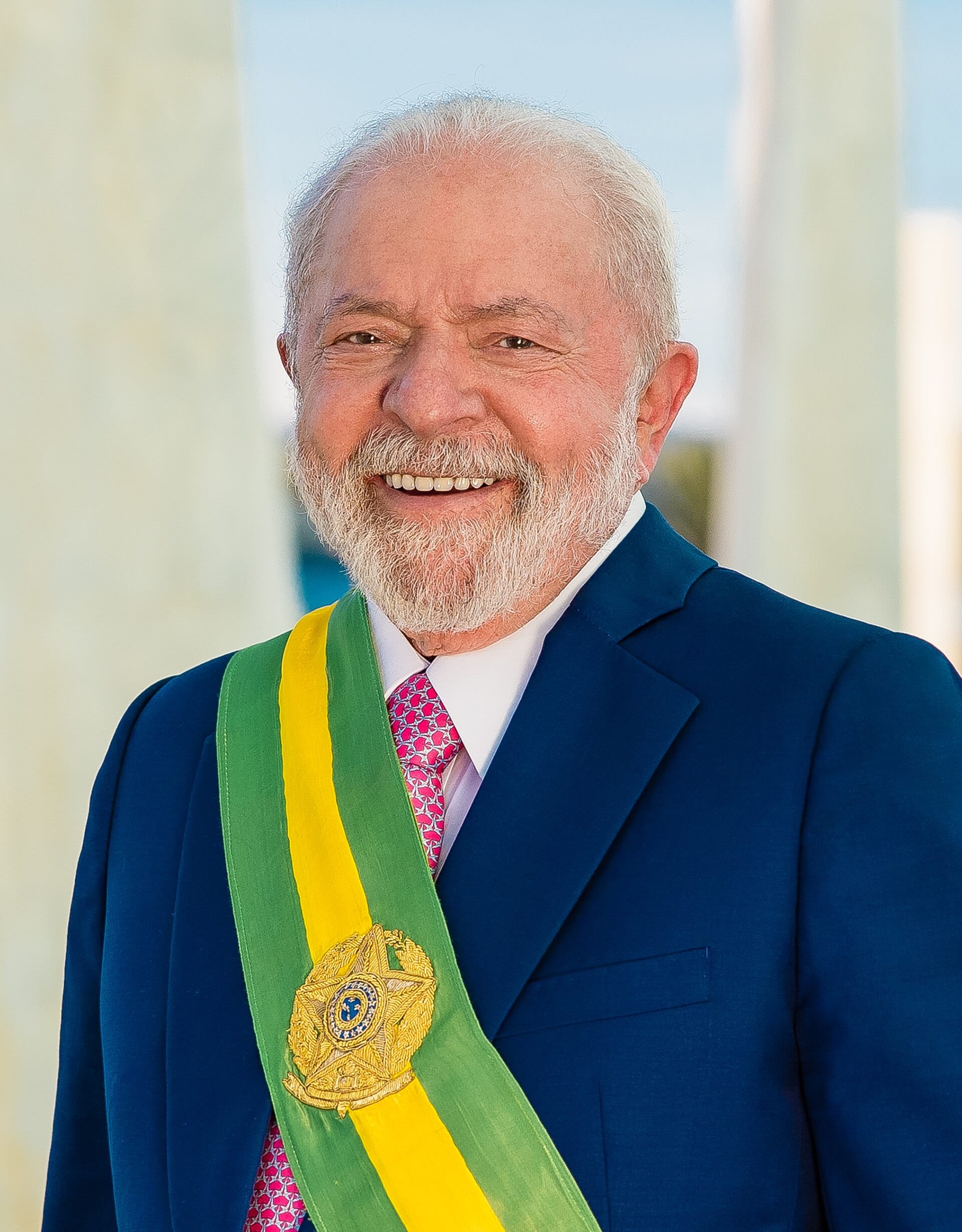 El presidente Lula da Silva sonríe con la banda presidencial verde y amarilla sobre un traje azul marino.