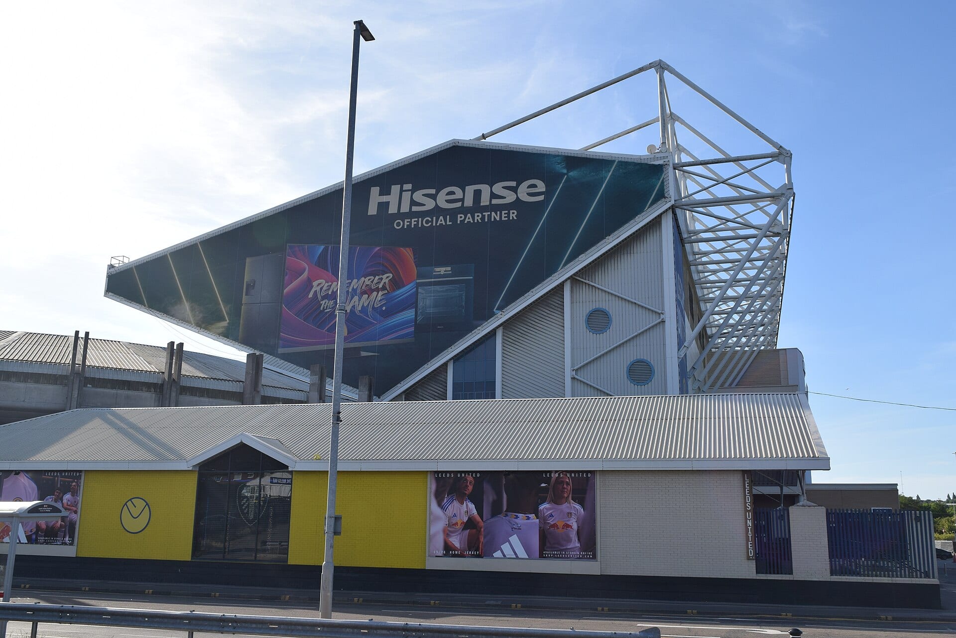 Exterior de la tribuna este de Elland Road, con una estructura de acero blanca y la tienda del club en la planta baja.