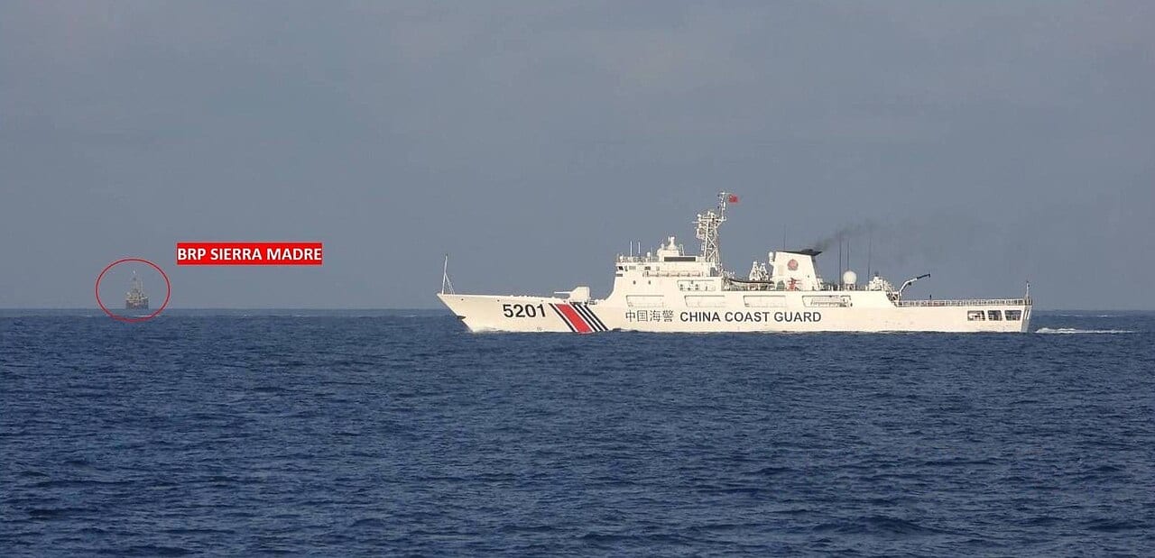 Un buque de la guardia costera china navega junto al puesto filipino en un arrecife del Mar de China Meridional.