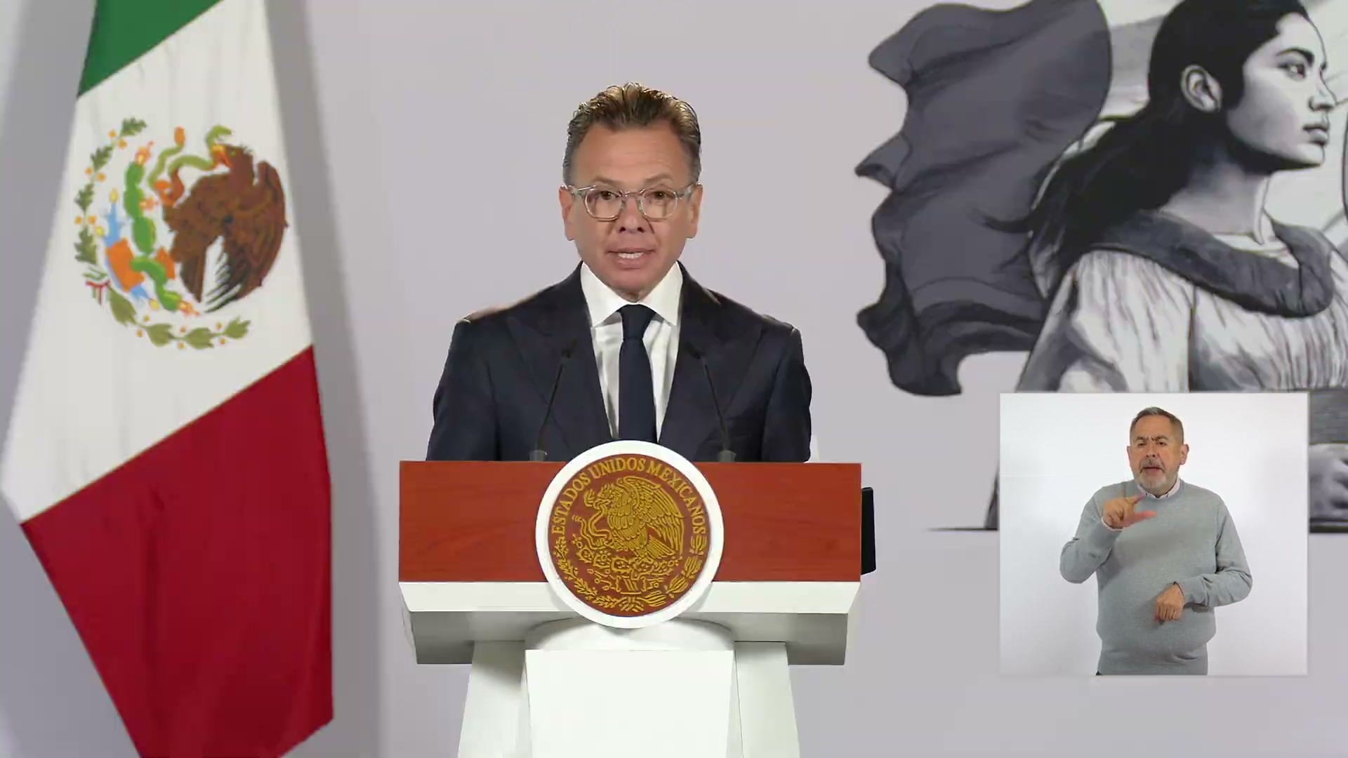El gobernador Pablo Lemus habla ante un podio con el escudo nacional, con un intérprete de lengua de señas en un recuadro.