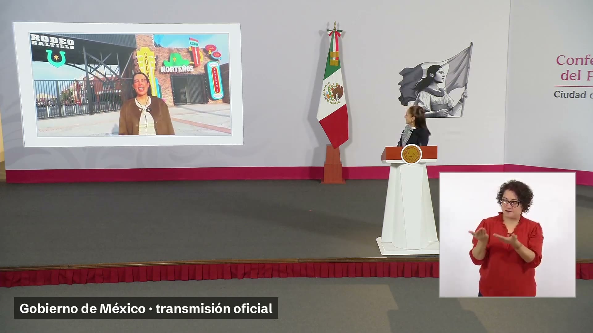 Un enlace desde el Rodeo Saltillo se proyecta en la pantalla de la conferencia, con la presentadora junto al podio.