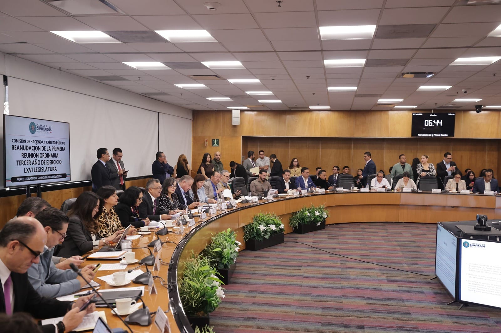 Integrantes de la Comisión de Hacienda sentados en una mesa curva en un salón de San Lázaro, con una pantalla con el nombre de la reunión.