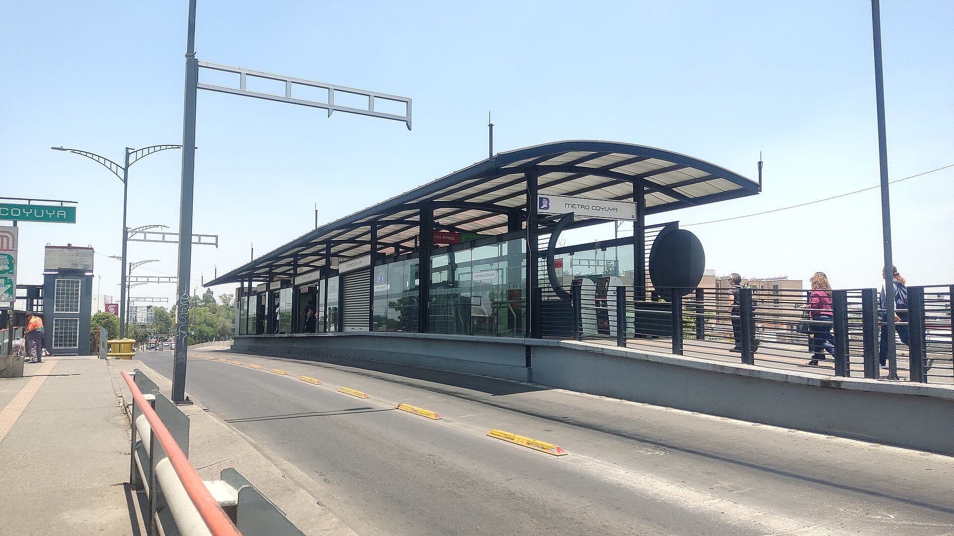 Estación Metro Coyuya del Metrobús, con su techo curvo, y el carril confinado vacío en primer plano bajo un cielo despejado.