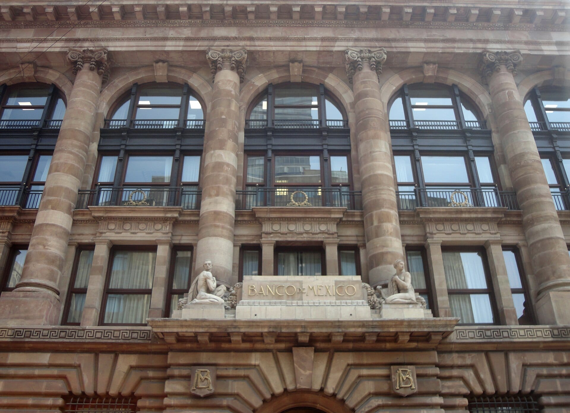 Fachada de piedra de un edificio institucional con columnas, sobre una calle de la Ciudad de México.