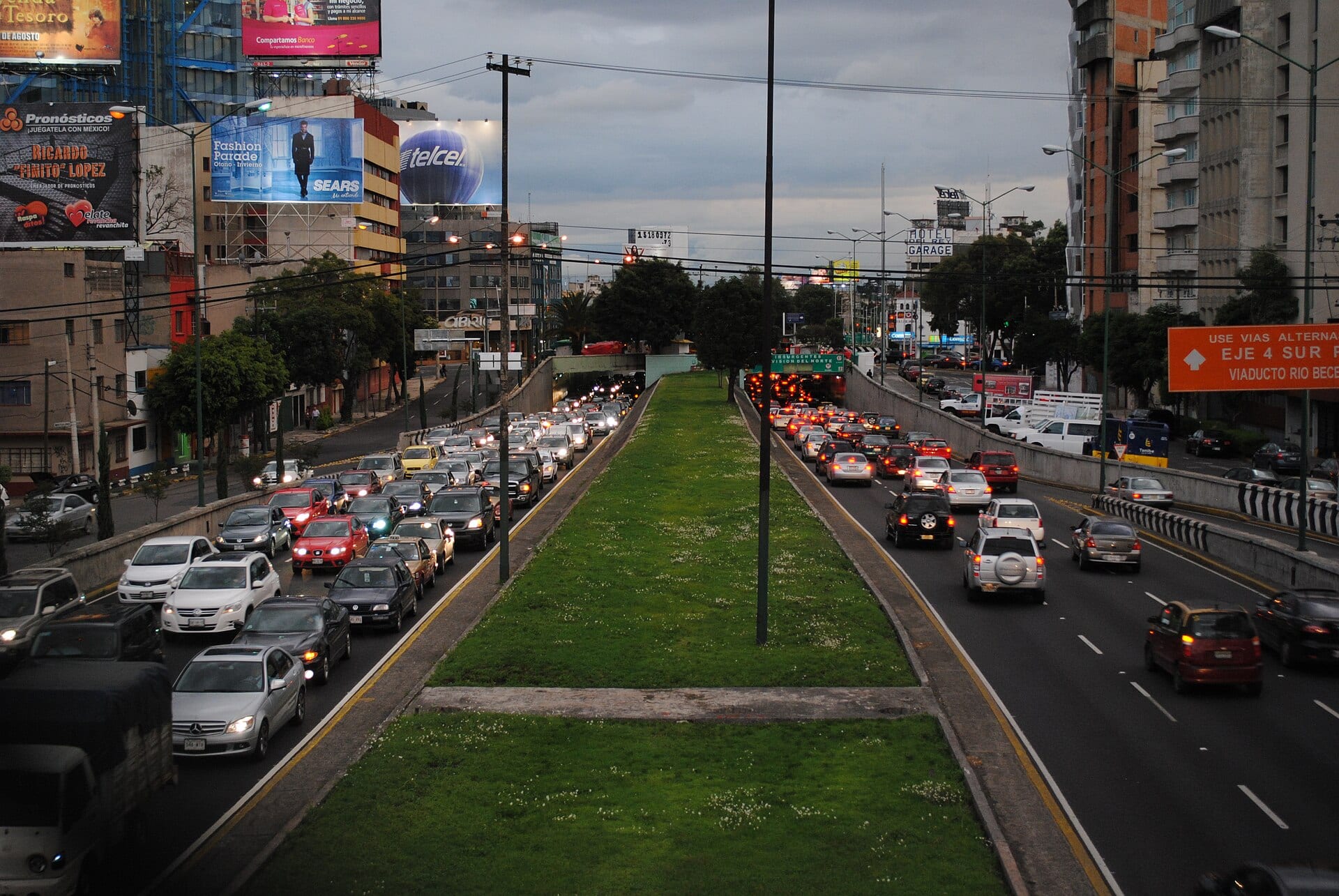 Autos circulan en ambos sentidos del Viaducto, con una franja de pasto al centro y un letrero naranja que indica Eje 4 Sur.