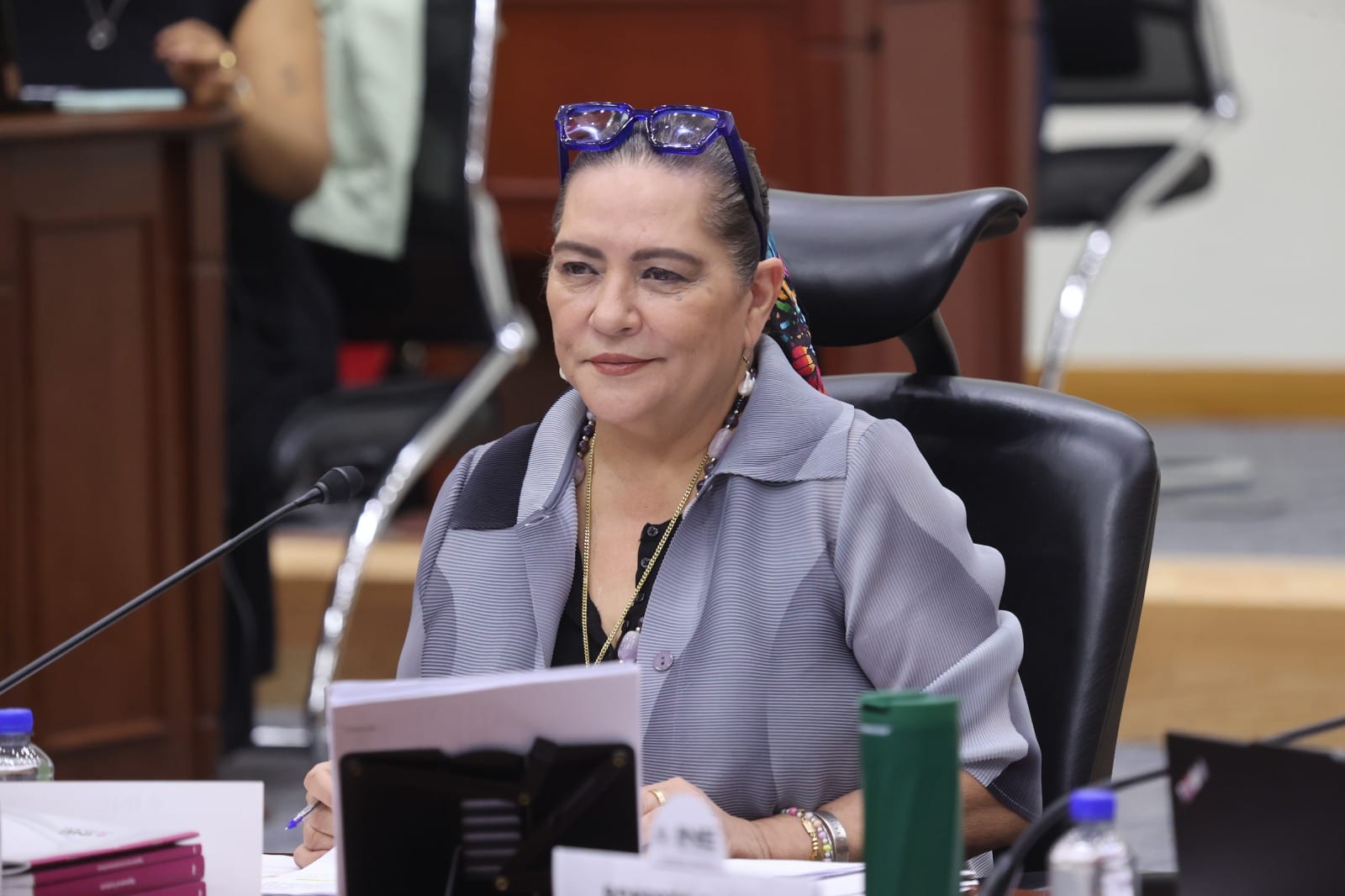 La consejera presidenta del INE, Guadalupe Taddei, sentada ante un micrófono en la mesa del Consejo General, con gafas azules sobre la cabeza.