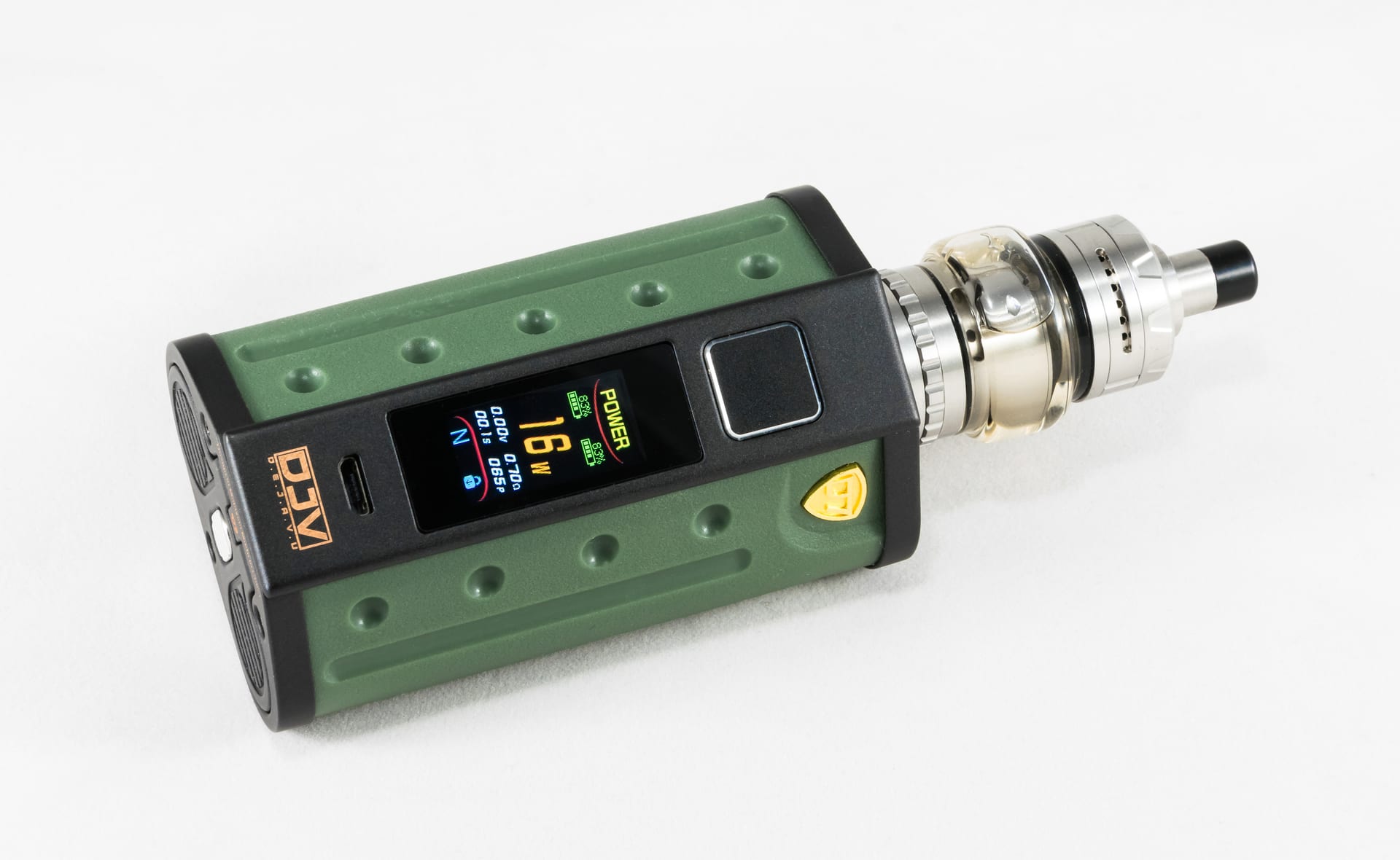 Un dispositivo vapeador de caja verde con pantalla digital y un tanque transparente con boquilla negra, sobre una superficie blanca.