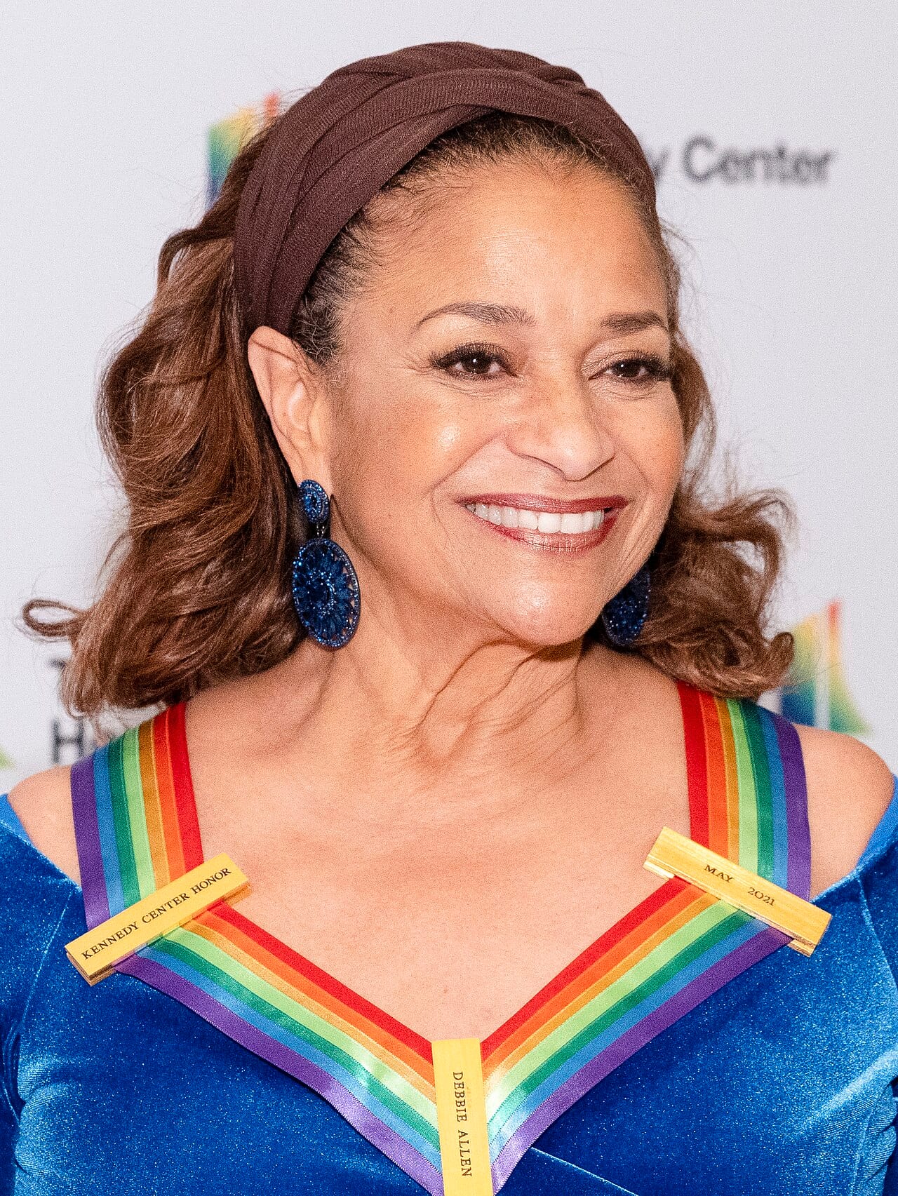 Retrato de Debbie Allen en una ceremonia de homenaje, de busto, con vestimenta formal y la mirada hacia la cámara.
