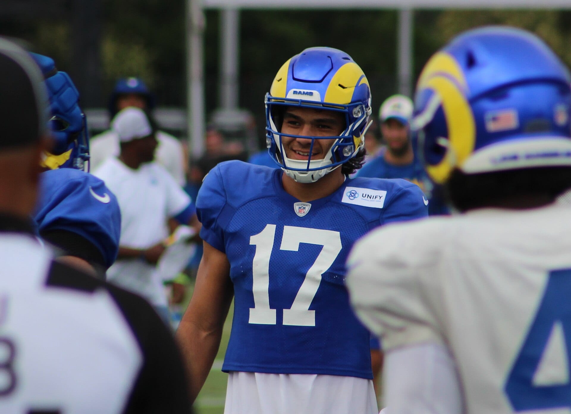 Un jugador de los Rams con el número 17 sonríe entre compañeros durante una sesión de entrenamiento.