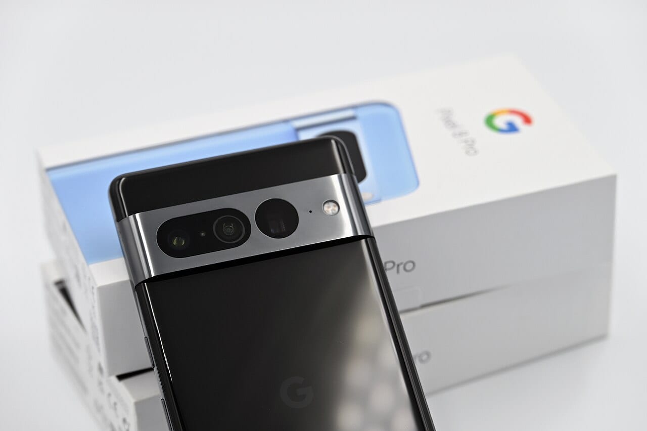The back of a black Google Pixel phone with a silver camera bar, resting on the model's white box.