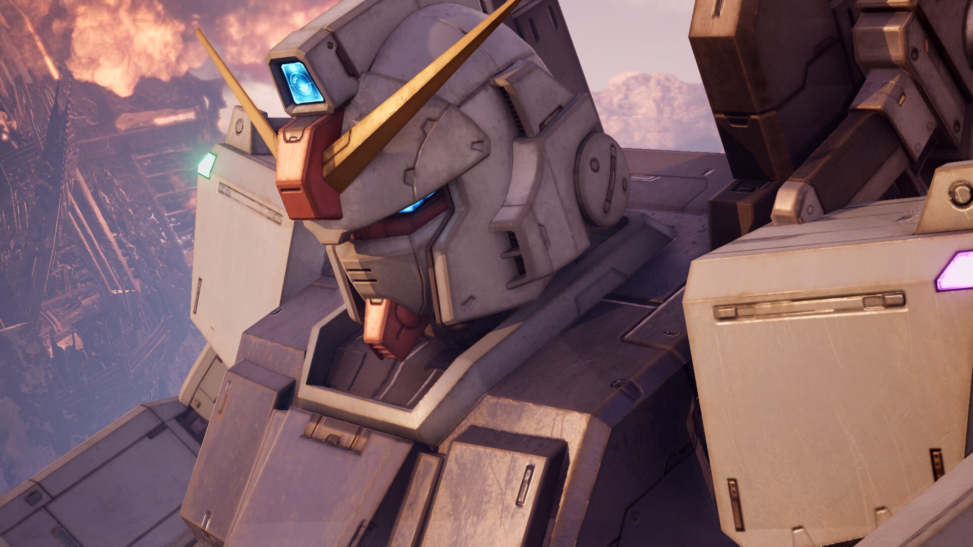 Close-up of a Gundam's head with a blue visor over a burning city, in a screenshot from the game.