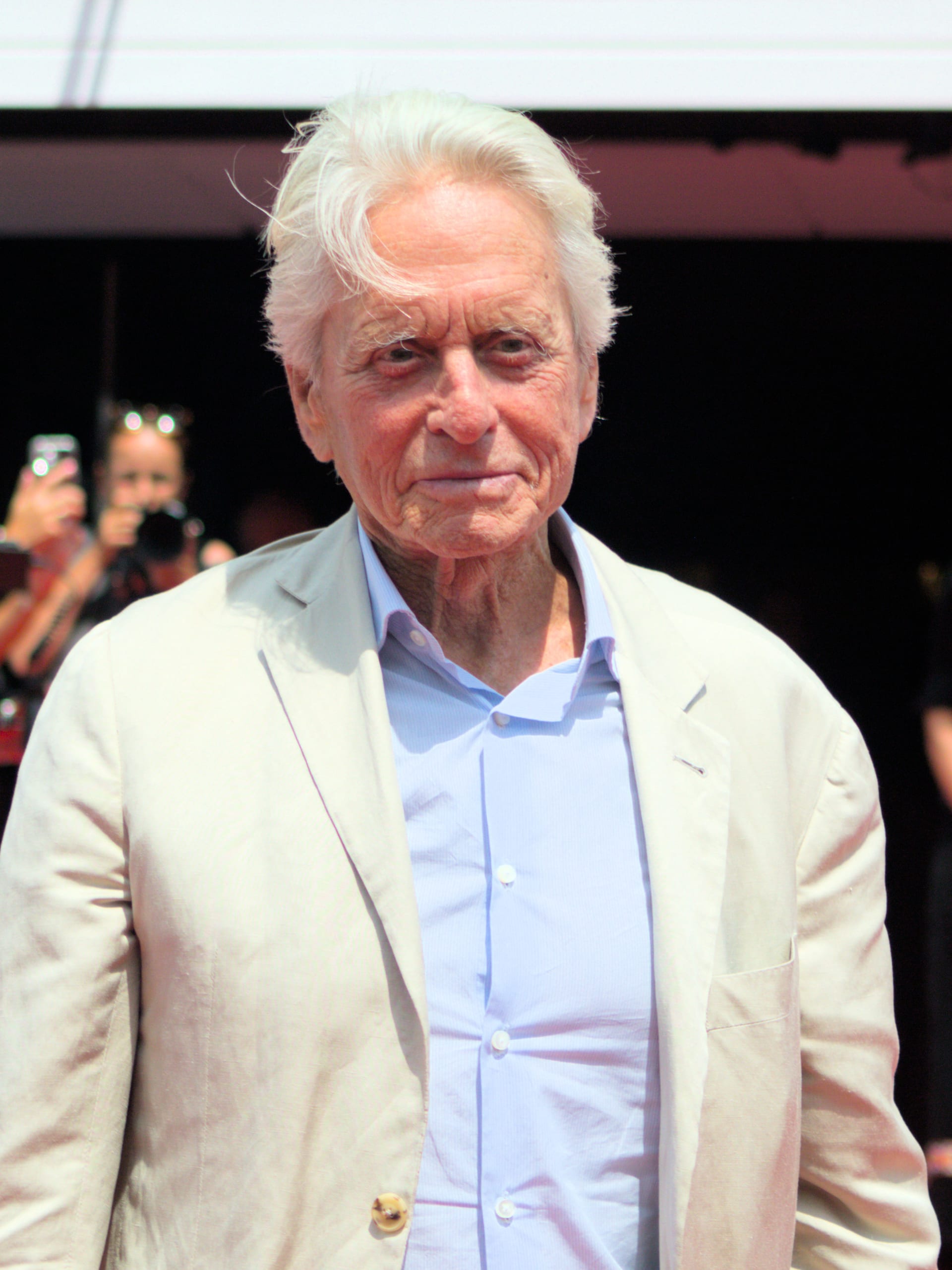 Michael Douglas, de cabello canoso, con saco claro y camisa azul, durante un evento del festival de cine de Karlovy Vary.