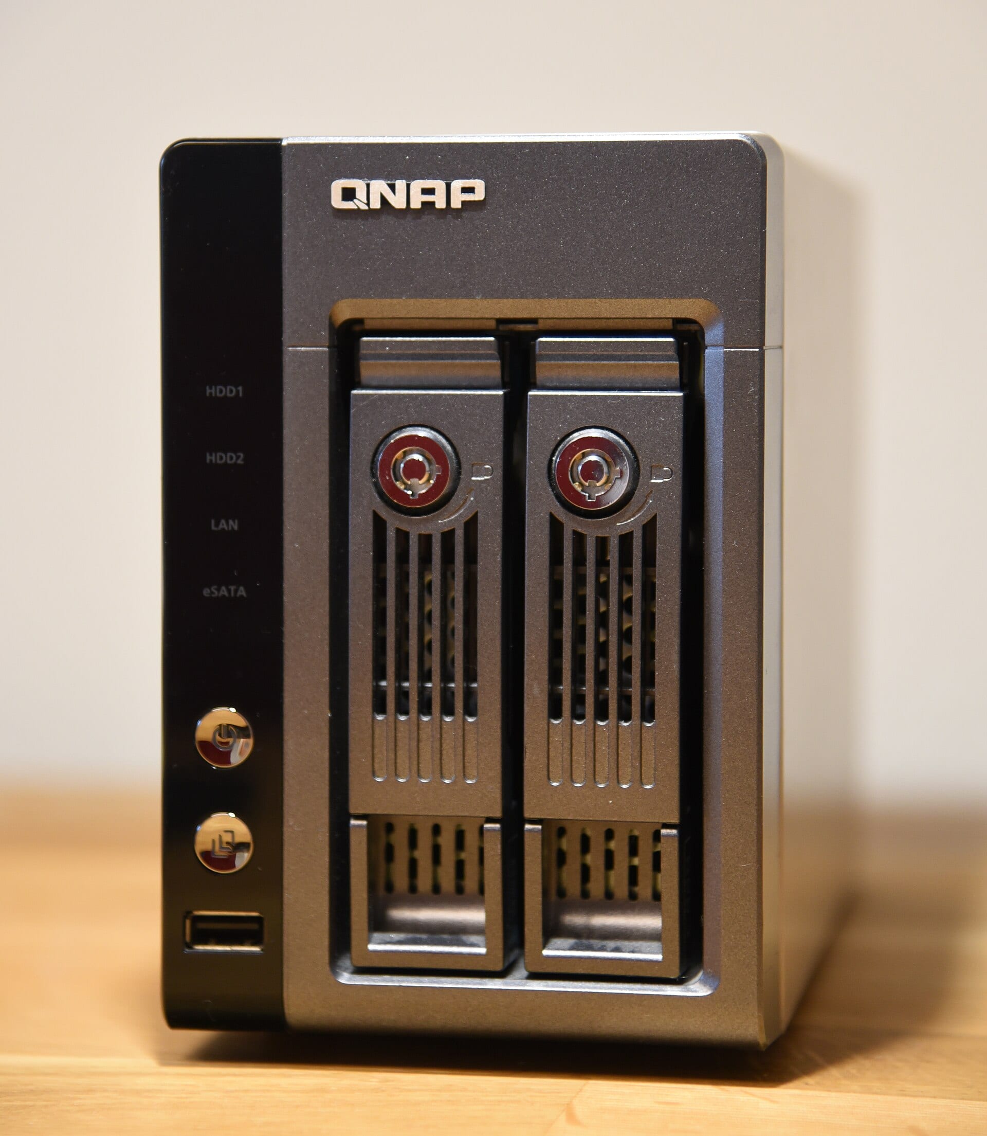 Equipo NAS de QNAP visto de frente, con dos bahías para discos, el logotipo de la marca y los indicadores HDD1, HDD2, LAN y eSATA.
