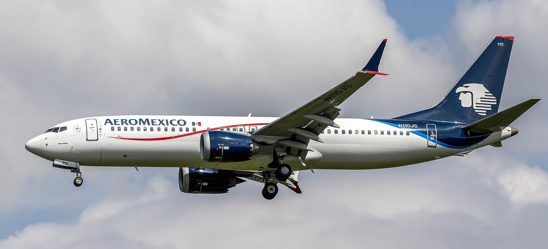 Un avión Boeing 737 MAX con la librea de Aeroméxico desciende en aproximación final con el tren extendido.