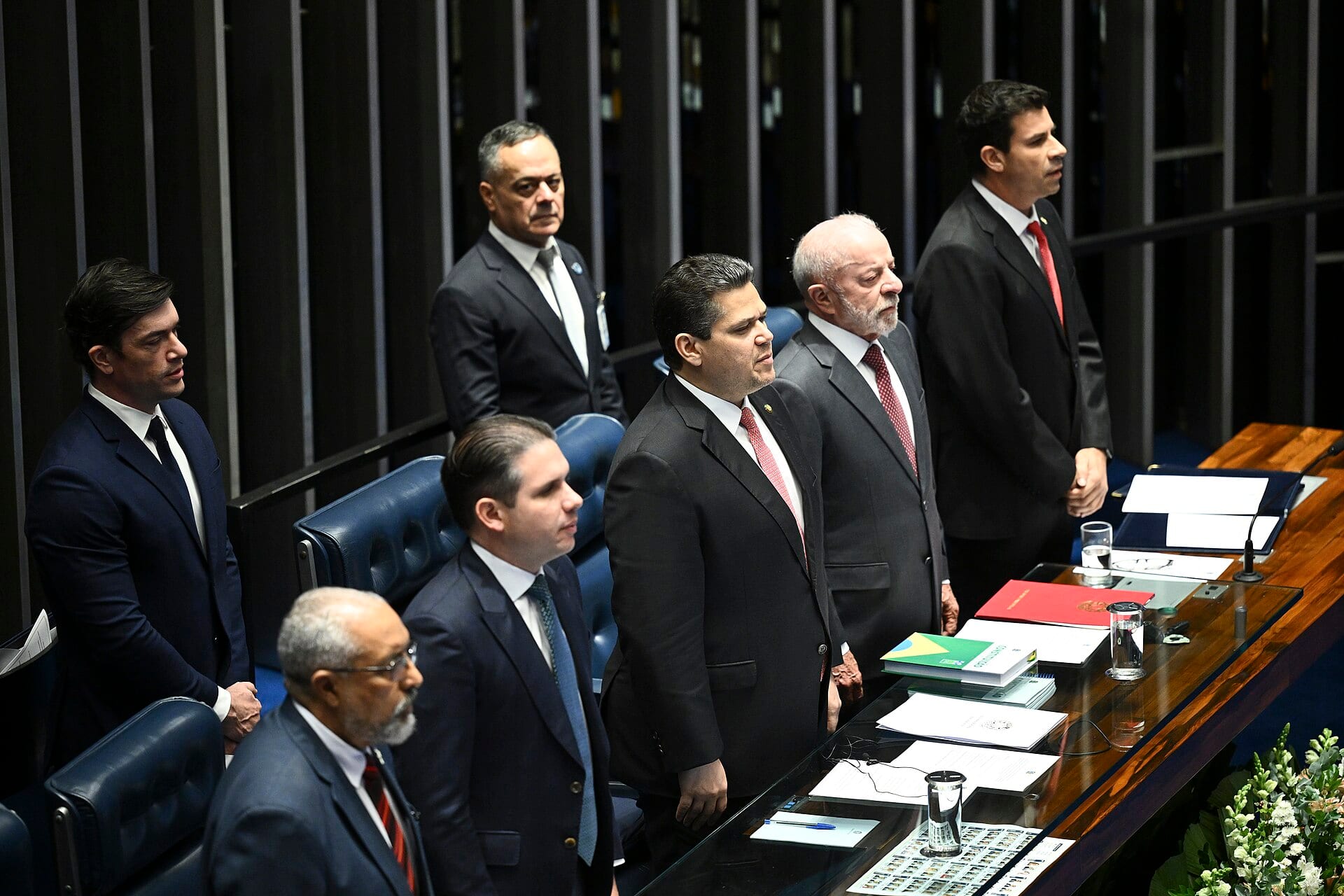Lula y el presidente del Senado, Davi Alcolumbre, de pie en la mesa del plenario durante la sesión solemne de promulgación.