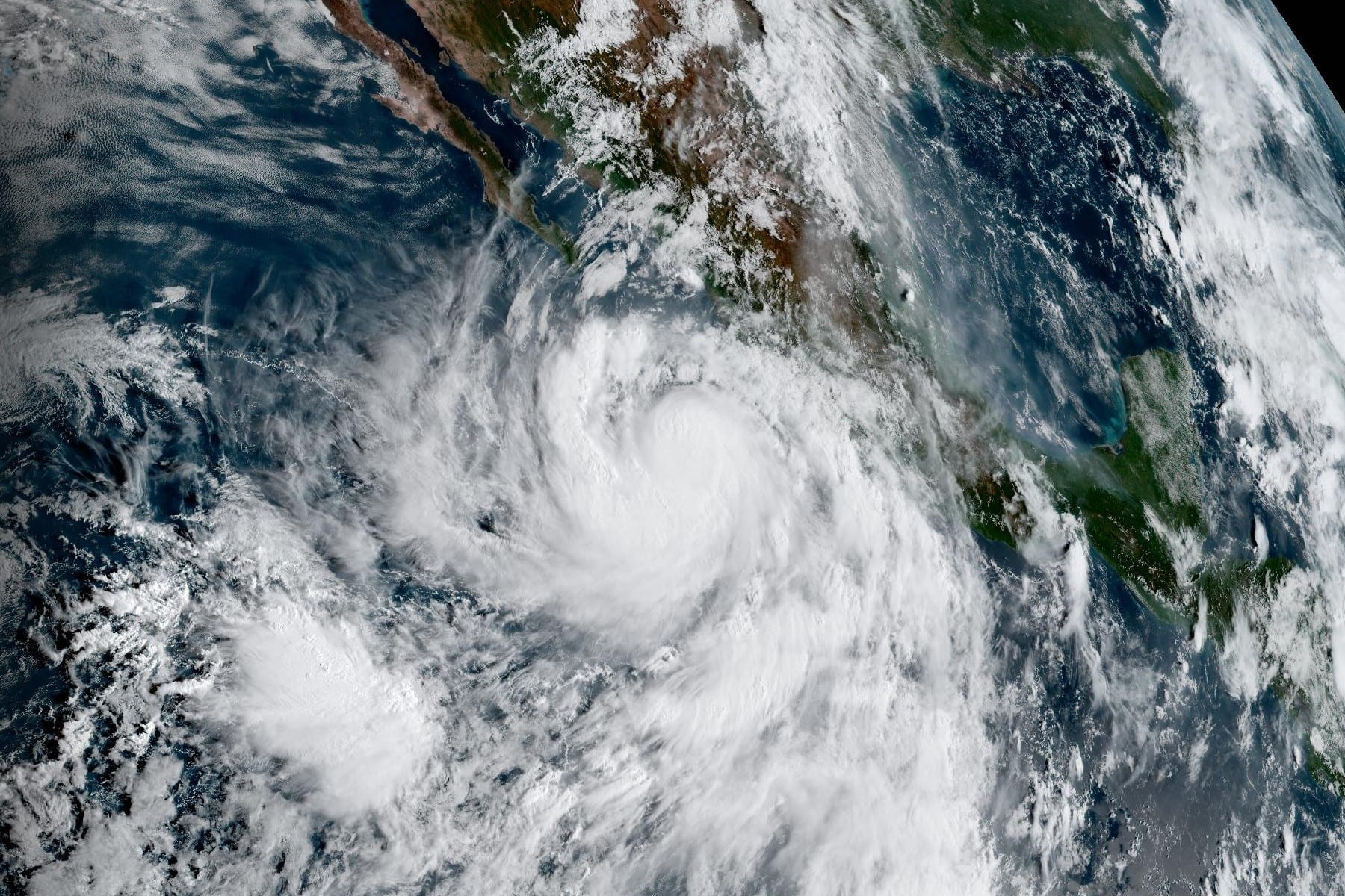 Imagen de satélite de un huracán con un ojo definido frente a la costa del Pacífico mexicano, con Baja California y el continente al norte.