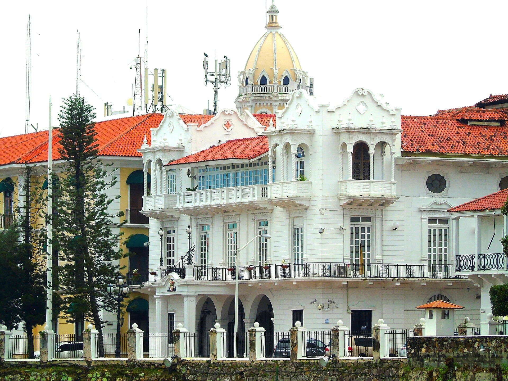 Fachada blanca del Palacio de las Garzas, sede de la Presidencia de Panamá, con techos de teja roja y una cúpula amarilla al fondo.