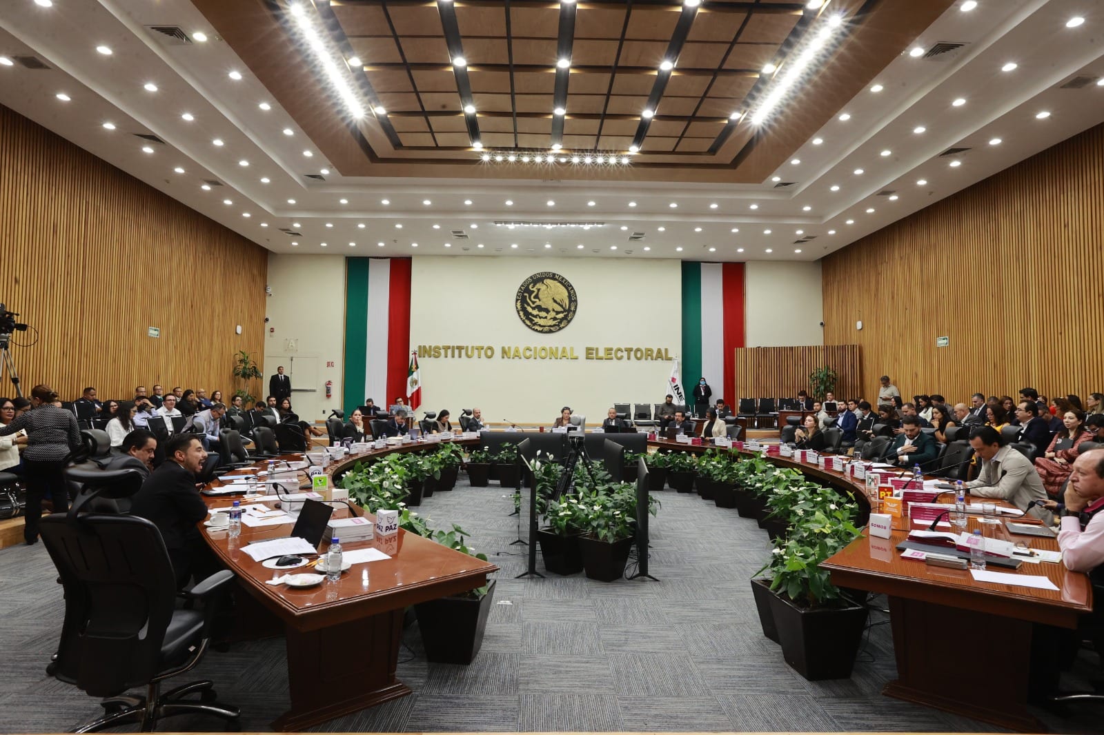 Sala de sesiones del Consejo General del INE, con las mesas en semicírculo y el letrero del Instituto Nacional Electoral al fondo.
