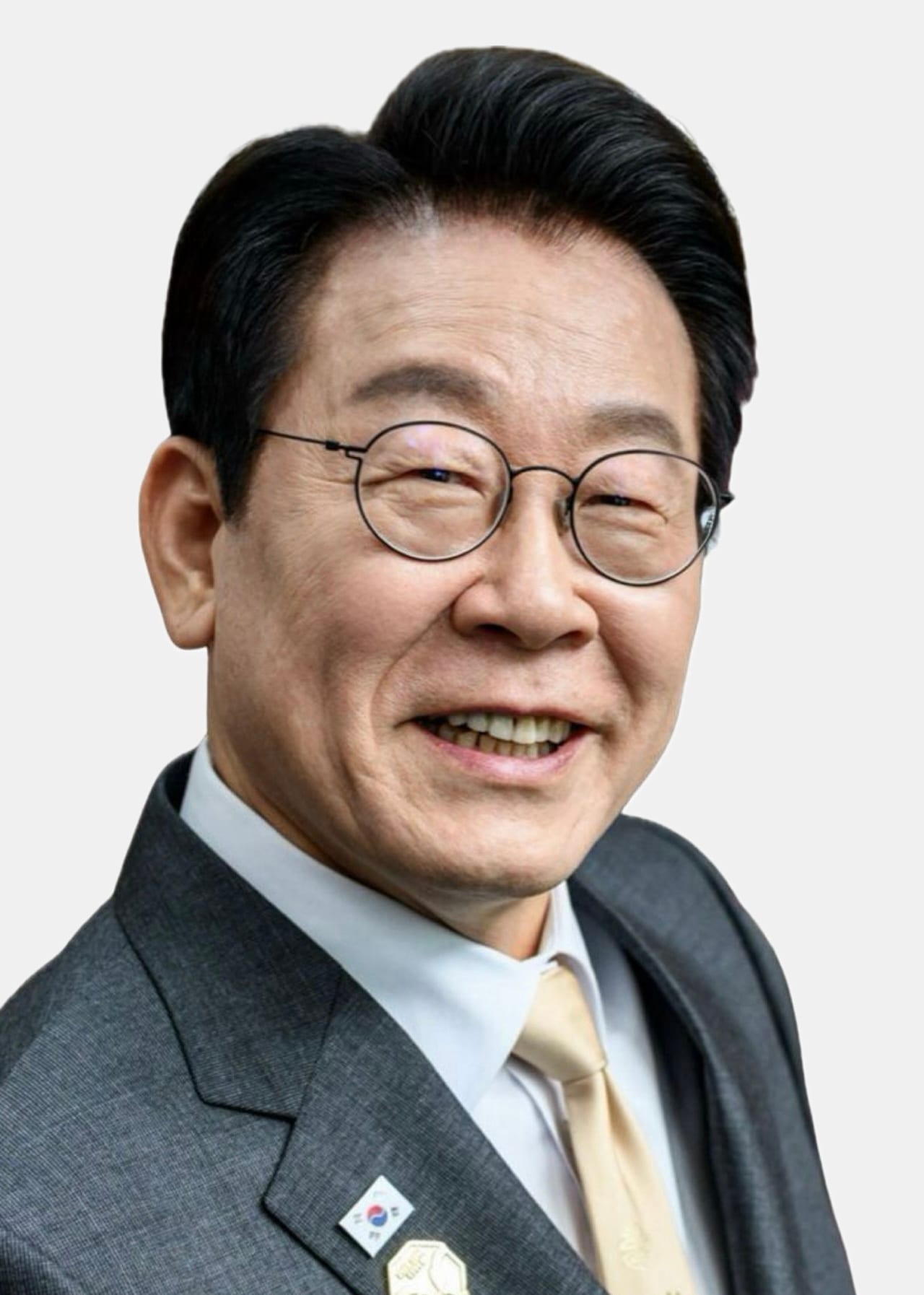 Retrato de un hombre sonriente con lentes redondos, traje gris y corbata dorada, sobre un fondo claro.