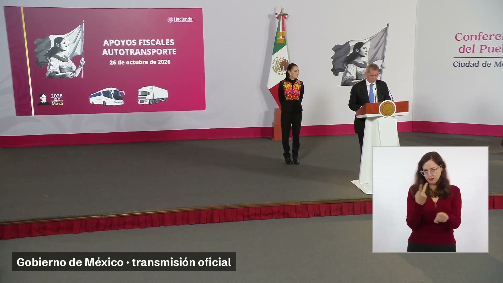 El secretario de Hacienda habla en el podio de la mañanera junto a una lámina titulada Apoyos fiscales autotransporte; la presidenta Claudia Sheinbaum está de pie a su lado.