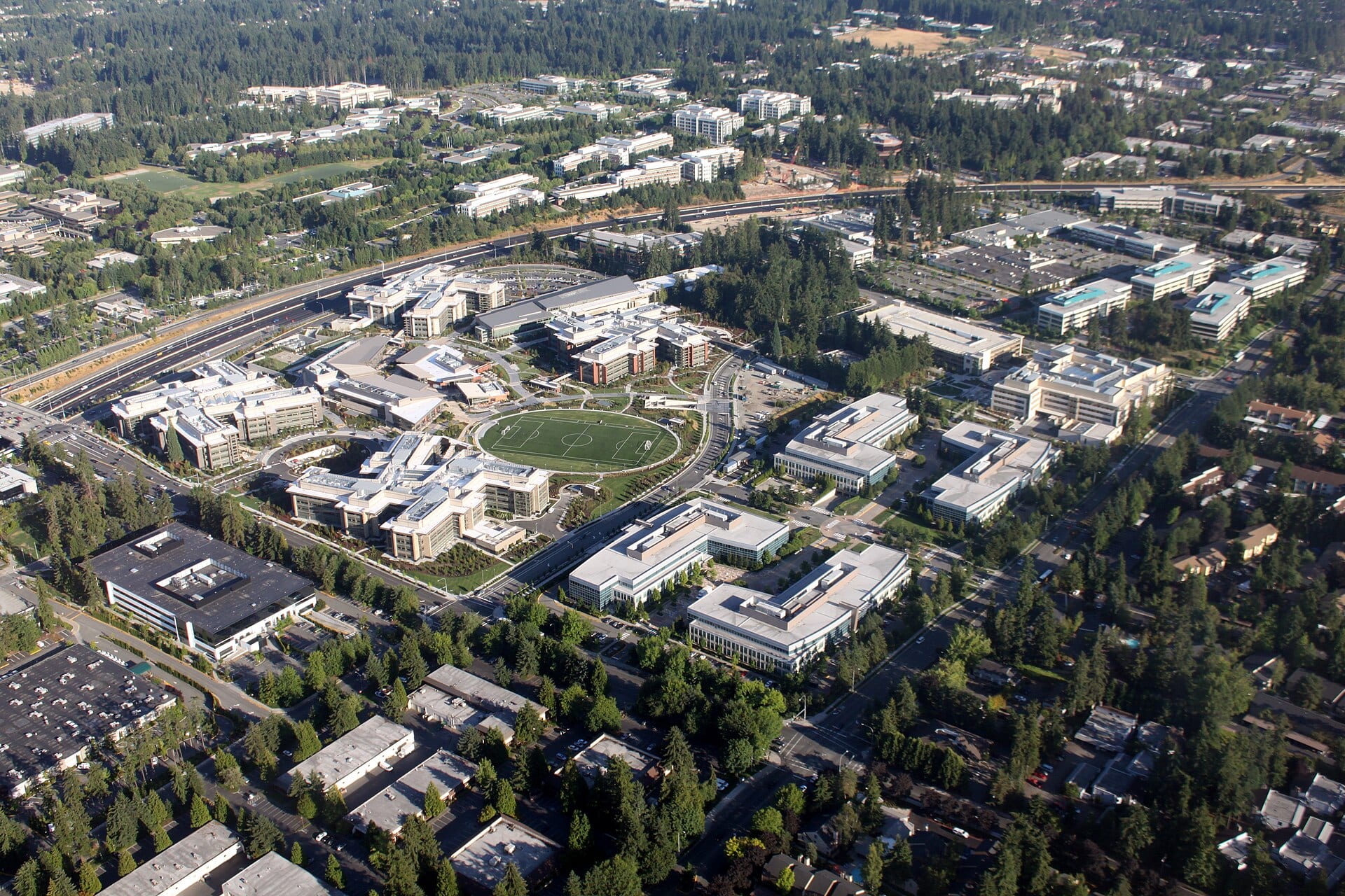 Vista aérea de los edificios de oficinas del campus de Microsoft en Redmond, rodeados de bosque y una autopista.