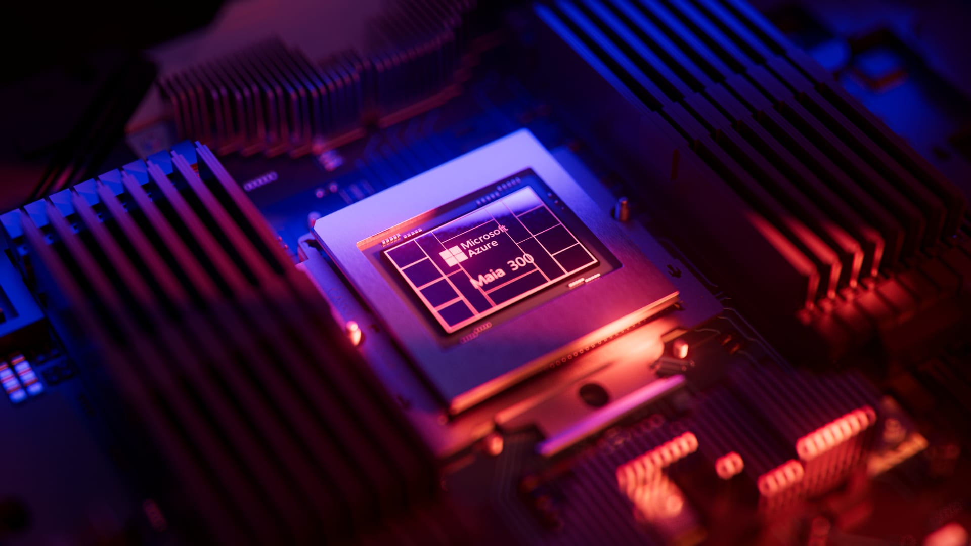 Close-up of the Maia 300 prototype chip on a board, with the Microsoft Azure logo and a block pattern on the package, under blue and red light.