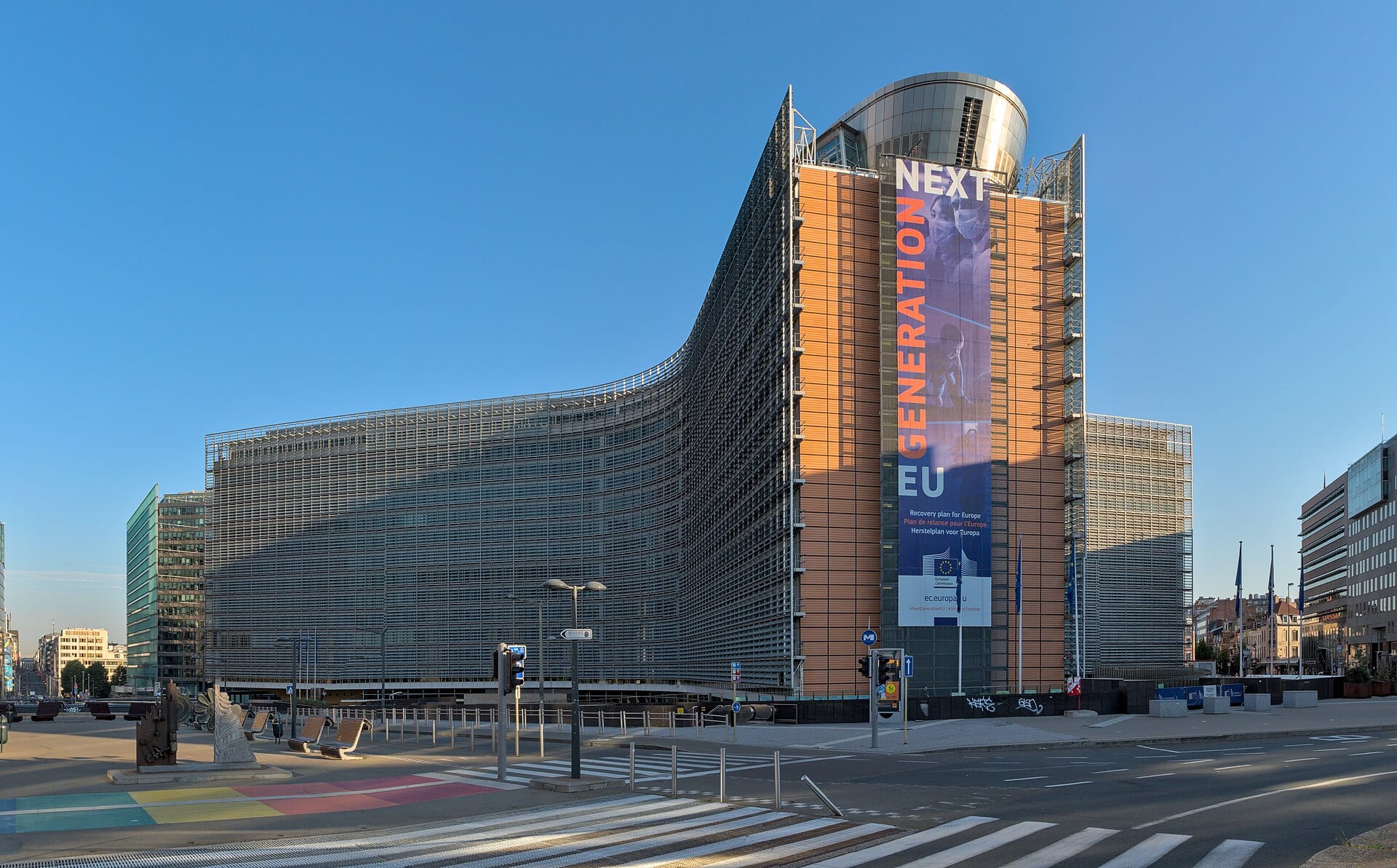 The curved facade of the Berlaymont building, the European Commission headquarters in Brussels, under a clear sky.
