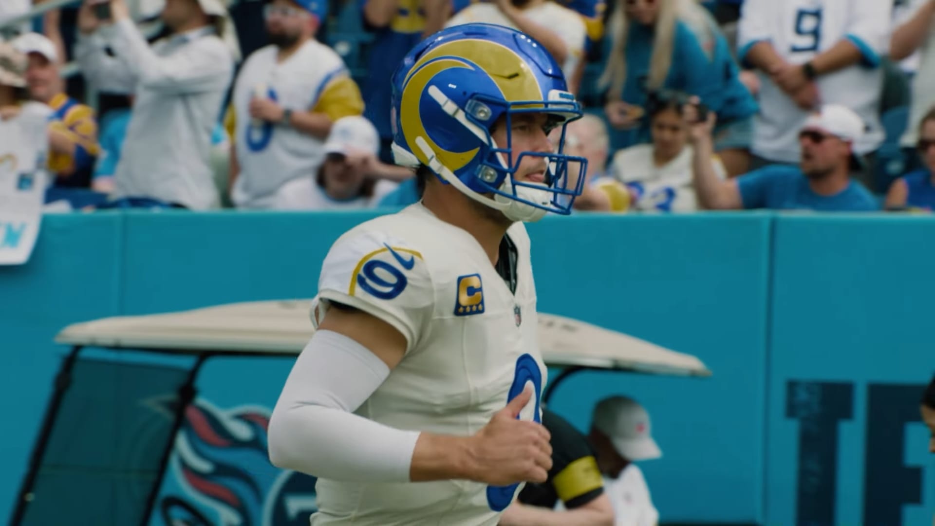 El mariscal de campo de los Rams, con el número 9 y uniforme blanco, trota sobre el terreno de juego previo a un encuentro.